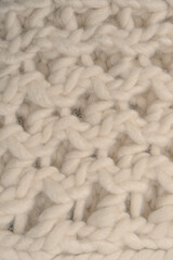 A fragment of beige knitted fabric, knitted from white sheep wool.