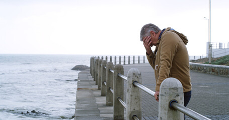 Senior man, thinking and sad by sea promenade with headache, stress and reflection. Person, depression and insight for mistake, crying and decision with anxiety by ocean, waves and outdoor in Italy