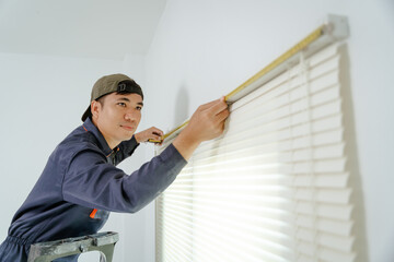 Installer carefully fitting blinds in a corporate boardroom, ensuring perfect alignment.
