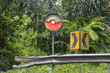 broken convex mirrors and broken traffic signs on the side of the road