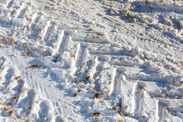The tire tracks in the snow are deep and wide