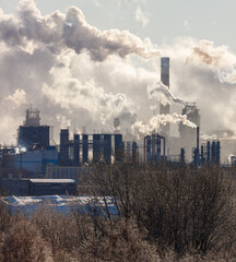 A city skyline with a large factory emitting smoke