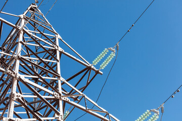 A tall power tower with green and white wires