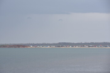 Naklejka premium Coastal view of a quiet village under an overcast sky near