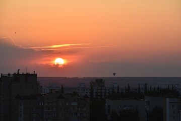 Stunning sunset over a cityscape with a hot air balloon