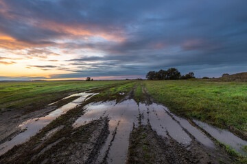 A field with a lot of mud and a cloudy sky