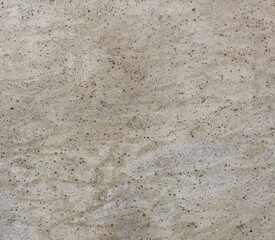 Grey and white stone surface with many small holes