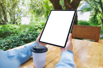 Mockup image of a woman holding digital tablet with blank white desktop screen in the outdoors