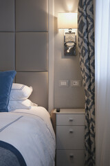 Luxurious porthole ocean view or oceanview or outside or exterior cabin on luxury cruiseship or cruise ship liner in modern interior design with bed, pillows, curtains