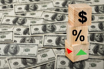 Wooden blocks with percentage sign, arrow and dollar banknotes