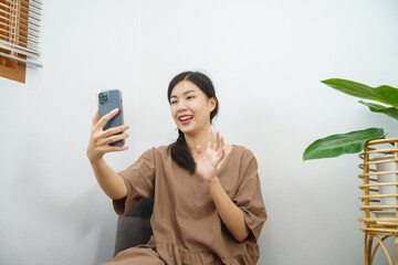 Beautiful Asian woman talking on smart phone have conversation online virtual chat video call with...