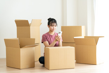 引越しでスマホを使う若い日本人の女性