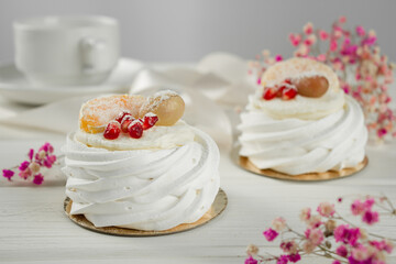 Meringue dessert with fruits. White dessert on a light table.