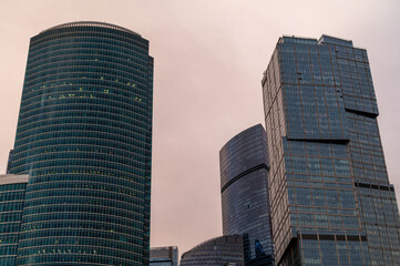 Skyscrapers in business district against blue sky. Looking Up high-rise office buildings. Evening...