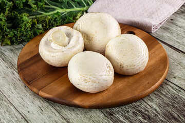 White champignon mushrooms heap over board