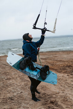 Woman packs up his kite surfing equipment as a storm approaches