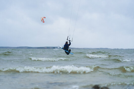 Woman packs up his kite surfing equipment as a storm approaches