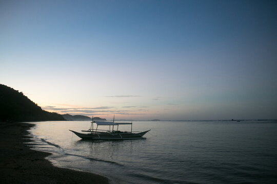 boat on a beach at sunset in Philippine islands
