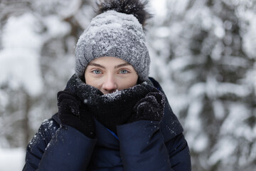 Portrait of a young adult woman in snowy forest