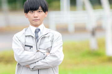 腕組みする作業服男性