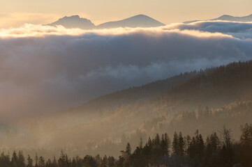 Panorama of mountain peaks above inversion with sunrise and morning frost in Beskydy mountains in the Czech Republic