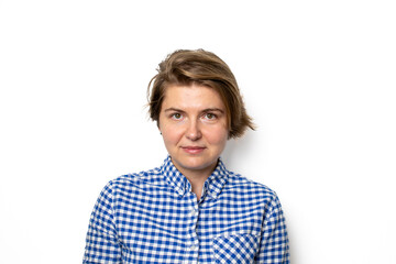Fototapeta premium A Caucasian woman in a blue checkered shirt poses confidently against a white background, symbolizing self-awareness and empowerment