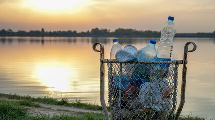 A sunset over a lake highlights plastic pollution, emphasizing environmental awareness and the...