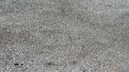 Close-up of a textured asphalt surface, highlighting urban infrastructure and road maintenance challenges in modern city environments