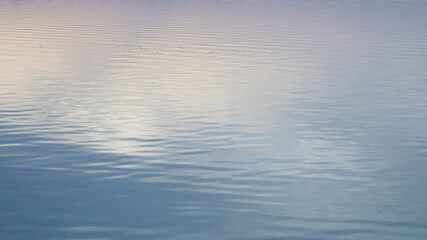 Calm ocean surface reflecting soft pastel sky colors, representing tranquility and relaxation, ideal for World Oceans Day themes