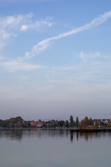 Obraz premium Tranquil lake scene with clear sky and autumn foliage, perfect for relaxation and mindfulness concepts