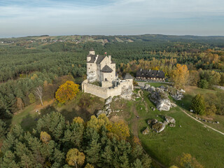 Naklejka premium Aerial drone view of Bobolice Castle in autumn.Old medieval fortress, royal castle in the village of Bobolice, Poland.Strongholds Eagles Nests in Polish Jurassic Highland.Limestone rock castle ruins.