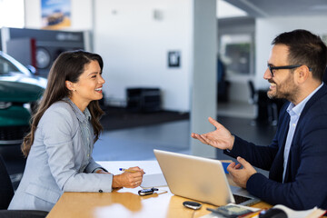 Customer buyer client wear shirt sign paper contract document with salesman choose auto want buy new automobile in car showroom vehicle salon dealership store motor show. Sales concept