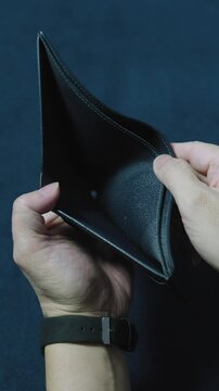 Man revealing an empty wallet, illustrating financial hardships and economic challenges
