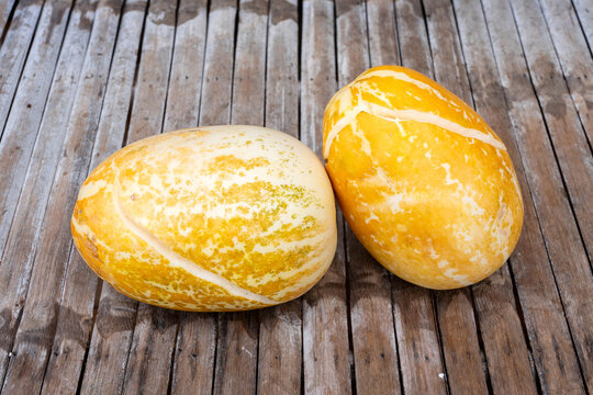 Fully ripe yellow Thai Muse Melon or Kharbuja is so ripe that it has split open. It has a sweet, cool and refreshing taste on bamboo table.