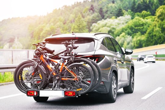 car with rear bike rack driving on highway near hills