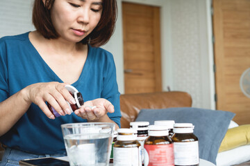 wellness Asian woman age 40 taking multi vitamins , food supplements , healthcare and medical concept