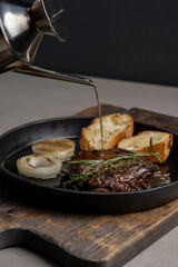 Pan-fried steak with toast and rosemary, drizzled with olive oil