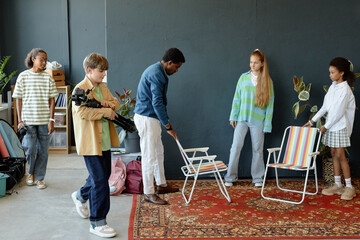 Full length shot of teenage kids setting up studio backstage preparing for podcast or video...