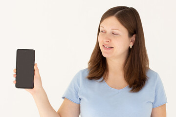 Fototapeta premium Happy woman feeling happiness and standing hold smartphone on white background. Cute girl smiling wearing casual blue t-shirt connect internet shopping online and present