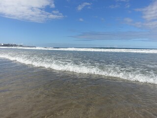 Serene beach with gentle waves under a clear sky