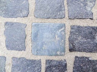 Abstract background of old cobblestone pavement up close. Stone texture of the pavement. Granite paving pavement background. Geneva