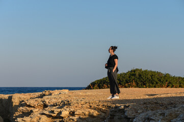 Obraz premium A serene moment by the coastal cliffs at sunset, embracing nature’s beauty and tranquility.