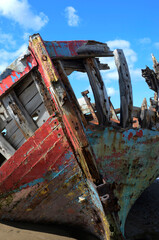 Colourful old fishing boat decaying on a beach