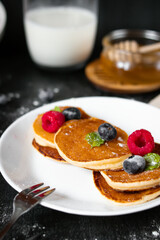 delicious pancakes with berries on a dark background. morning. breakfast