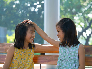 Elder sister comforts younger sister with love in the park.