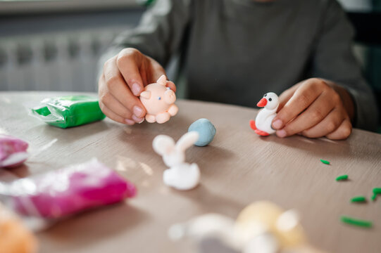 Boy playing with animals made from clay at table