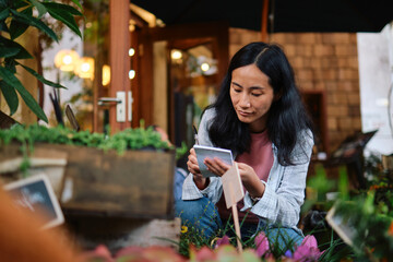 Gardener examining plants and making notes