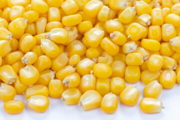And grains of corn on white. food grain concept. a handful of yellow and white grains of corn and vegetables on a white . a handful of green vegetables and grains lifestyle on a white.