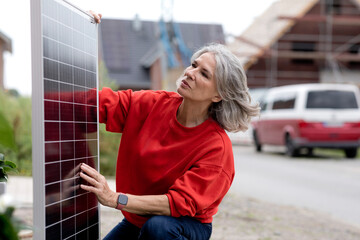 Senior woman examining solar panel