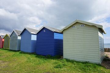 traditional wooden beach huts in a row on the coast. Colourful huts at the seaside